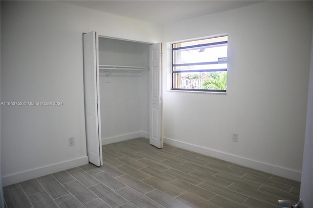 unfurnished bedroom with hardwood / wood-style flooring and a closet