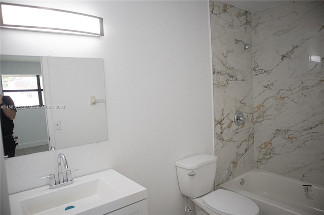 full bathroom with tiled shower / bath, vanity, and toilet