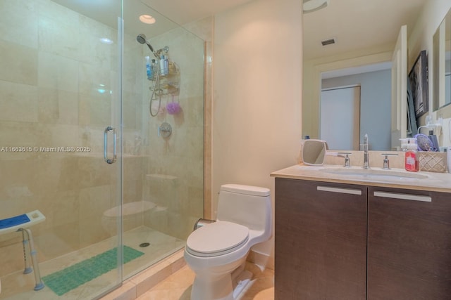 bathroom with vanity, toilet, a shower with door, and tile patterned flooring