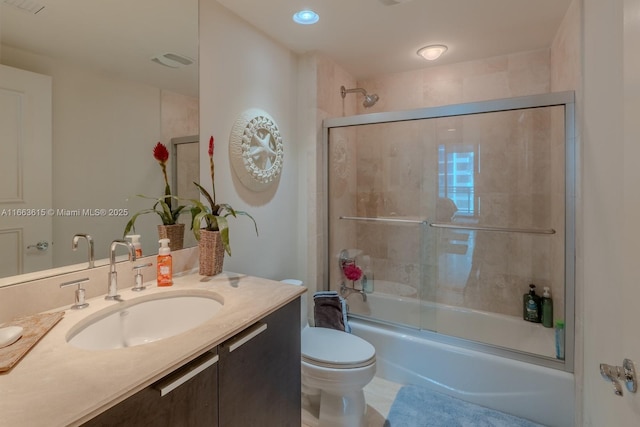 full bathroom with vanity, toilet, and bath / shower combo with glass door