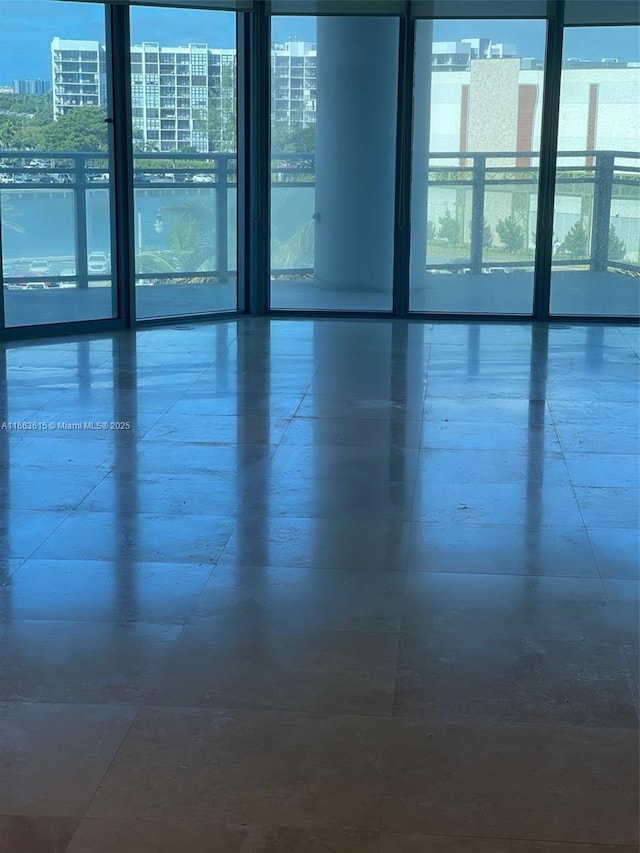 empty room featuring a water view and a wall of windows