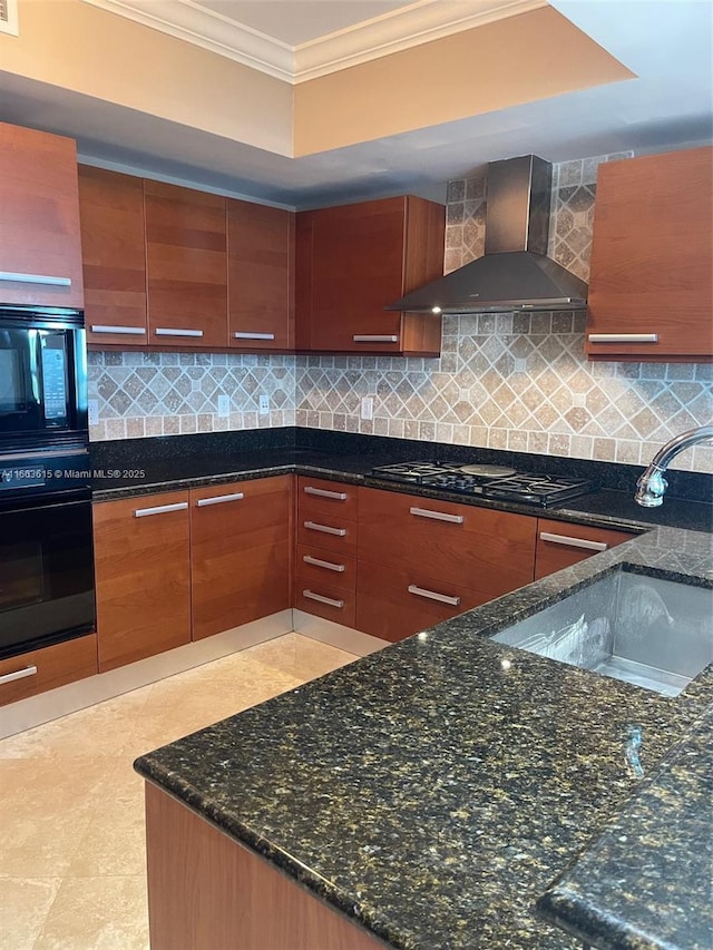 kitchen with wall chimney exhaust hood, black appliances, dark stone counters, and ornamental molding