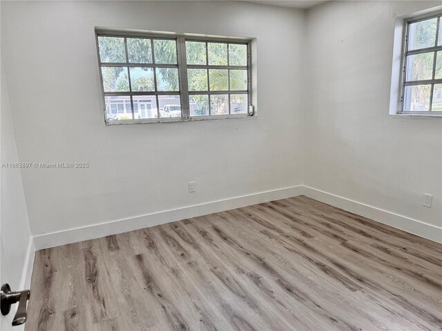 unfurnished room with a healthy amount of sunlight and light hardwood / wood-style floors