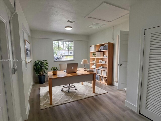 home office featuring a textured ceiling and light hardwood / wood-style flooring