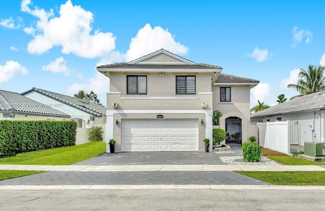 view of front of house with a garage, a gate, fence, and stucco siding