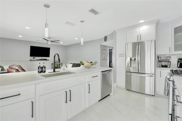 kitchen with pendant lighting, white cabinetry, sink, ceiling fan, and stainless steel appliances