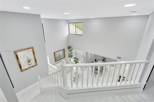 stairs with marble finish floor, visible vents, and recessed lighting