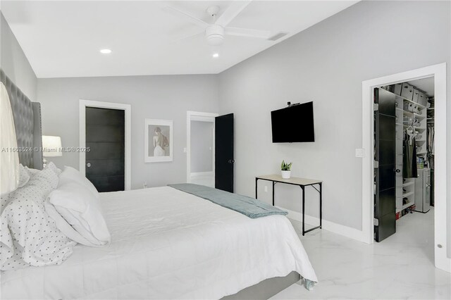 bedroom with a walk in closet, a closet, ceiling fan, and vaulted ceiling