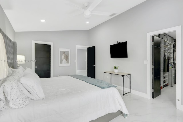 bedroom with a walk in closet, marble finish floor, lofted ceiling, a closet, and baseboards