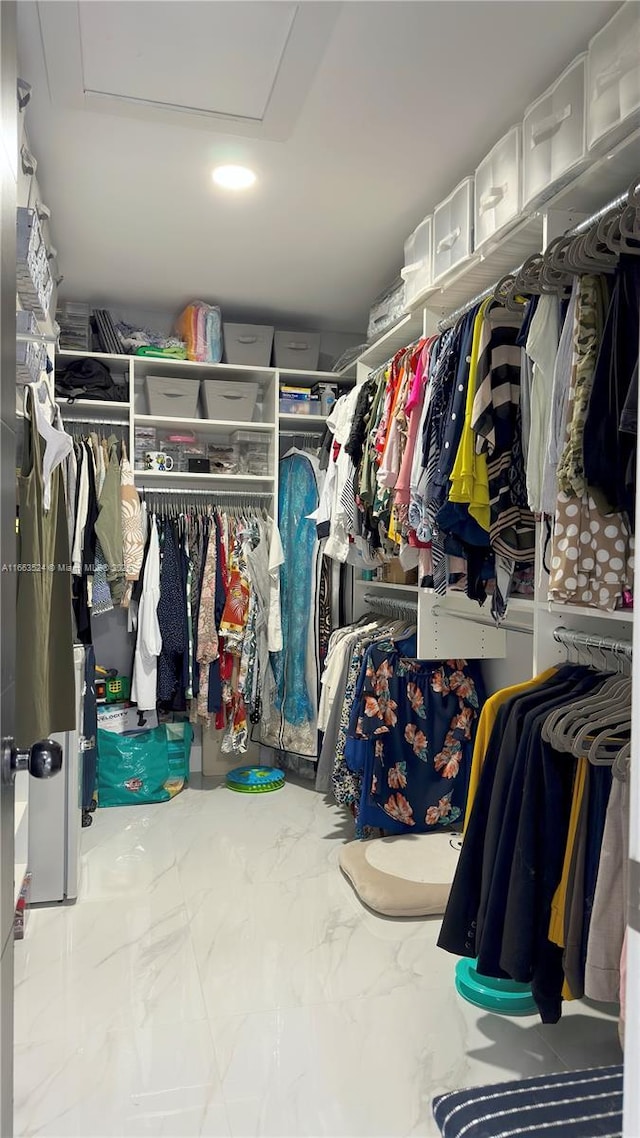 spacious closet with marble finish floor and attic access