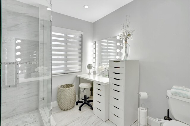 bathroom featuring a shower with door and toilet