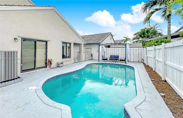 view of swimming pool featuring cooling unit, a pergola, and a patio area