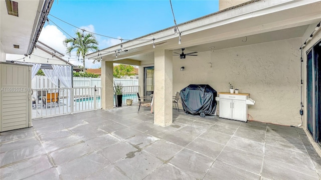 view of patio featuring ceiling fan and fence