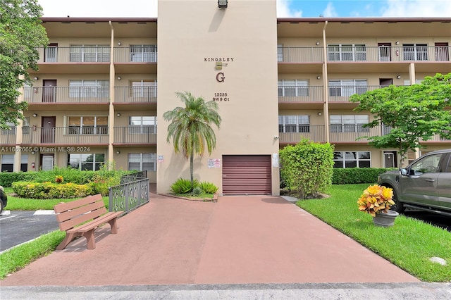 13255 SW 9th Ct Unit 114G, Pembroke Pines, FL 33027 - view of building exterior featuring a garage and concrete driveway