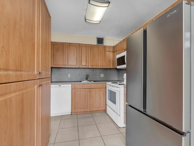 kitchen with white appliances, sink, light tile patterned floors, and tasteful backsplash