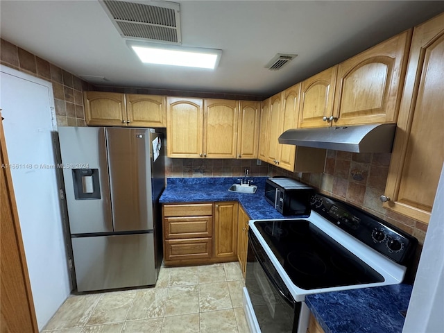 kitchen featuring backsplash, sink, light tile patterned floors, and stainless steel appliances