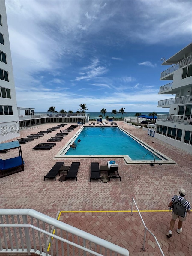 view of pool with a water view and a patio area