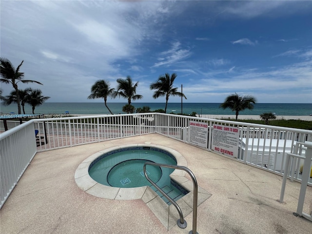 view of pool featuring a community hot tub and a water view