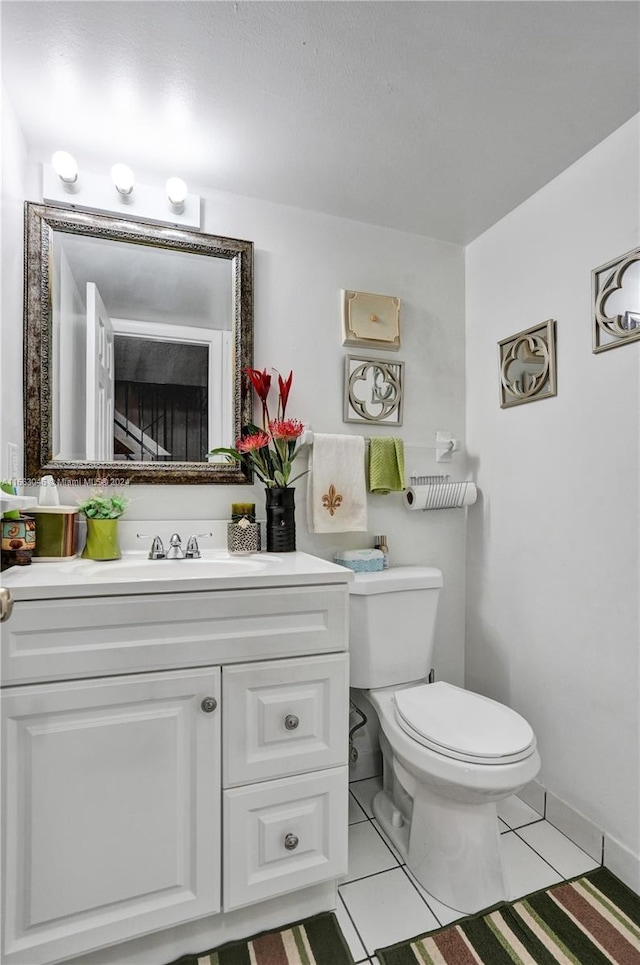 bathroom featuring toilet, vanity, and tile patterned floors