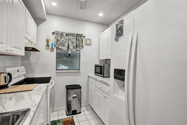 kitchen featuring white refrigerator with ice dispenser, range, light tile patterned floors, light stone counters, and white cabinetry