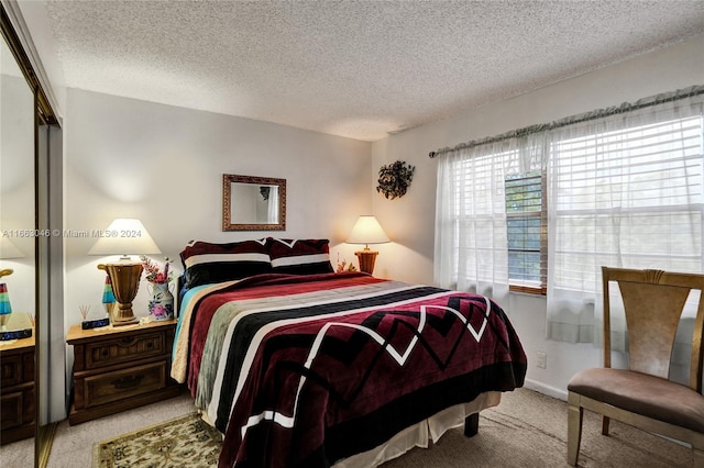 bedroom featuring light colored carpet, a textured ceiling, and a closet