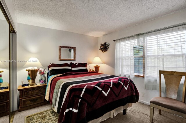 bedroom with ensuite bath, a textured ceiling, and a closet