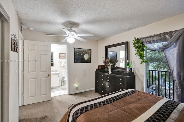 carpeted bedroom featuring ceiling fan, ensuite bathroom, and a textured ceiling