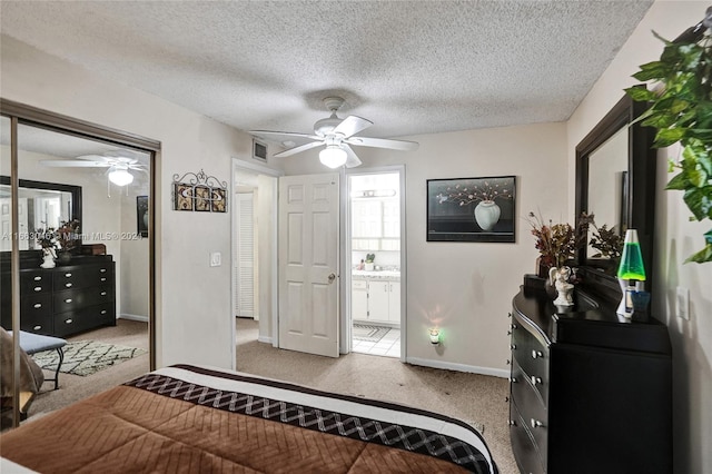 bedroom featuring ceiling fan, ensuite bathroom, and a textured ceiling