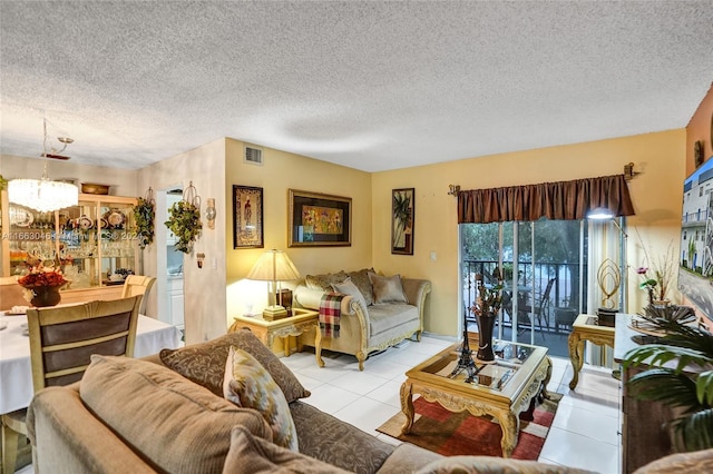 tiled living room featuring a chandelier and a textured ceiling