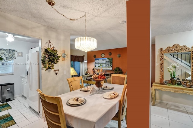 dining space with light tile patterned floors, a textured ceiling, and an inviting chandelier