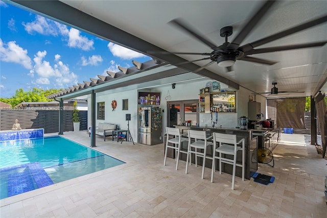 view of pool featuring a patio, an outdoor bar, ceiling fan, and pool water feature