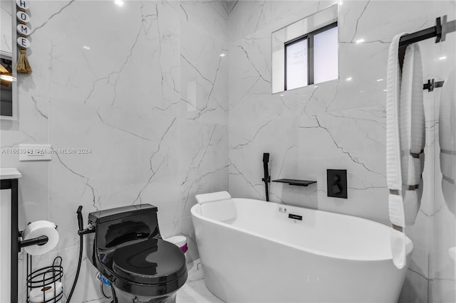 bathroom with tile walls, a bath, vanity, and toilet