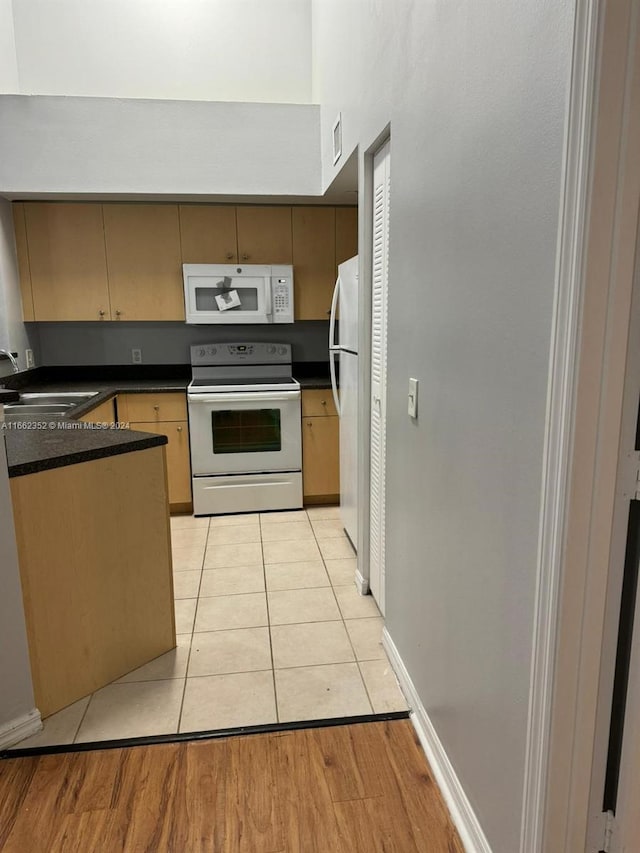 kitchen featuring white appliances, sink, and light hardwood / wood-style flooring