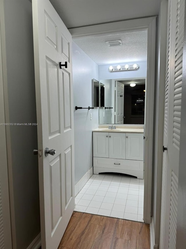 bathroom featuring vanity, a textured ceiling, and hardwood / wood-style flooring