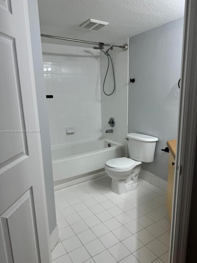 bathroom featuring a textured ceiling, tiled shower / bath combo, toilet, and tile patterned floors