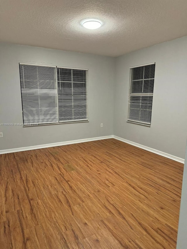 spare room with wood-type flooring and a textured ceiling