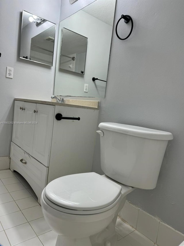 bathroom with vanity, toilet, and tile patterned floors