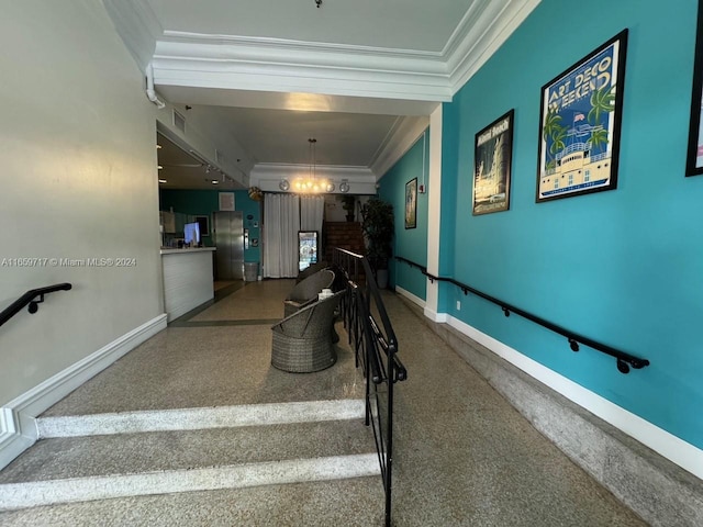 staircase with crown molding and an inviting chandelier