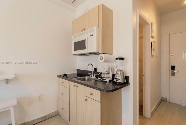 kitchen featuring ornamental molding, light brown cabinets, light hardwood / wood-style flooring, and sink