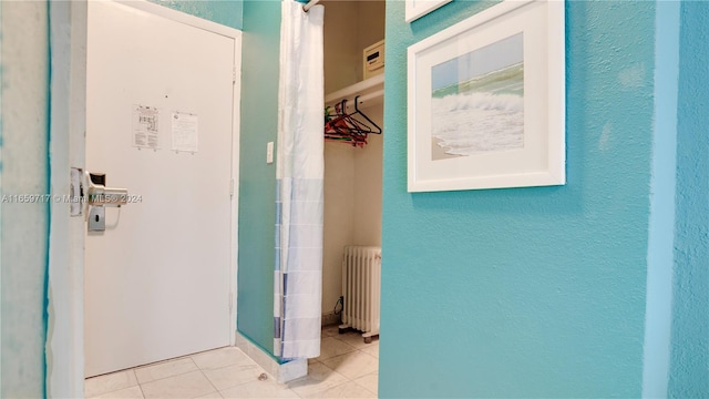 interior space with light tile patterned floors and radiator heating unit