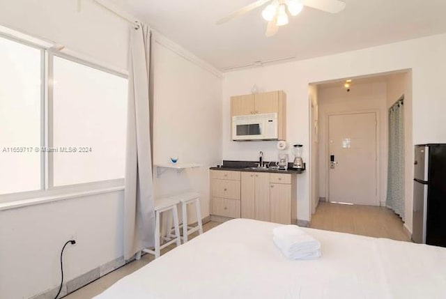 interior space featuring ceiling fan, stainless steel refrigerator, sink, and light hardwood / wood-style floors