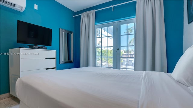 bedroom with access to outside, french doors, and a wall mounted air conditioner