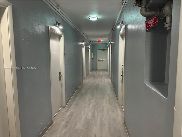 hallway featuring light hardwood / wood-style flooring and crown molding