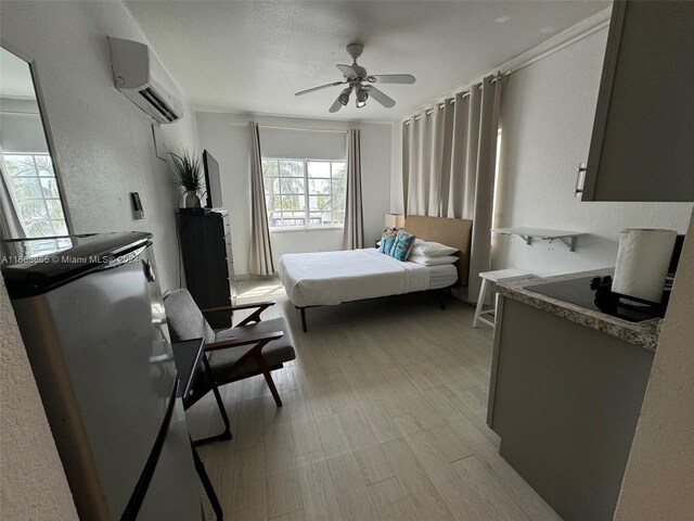 bedroom with ceiling fan, light wood-type flooring, and an AC wall unit