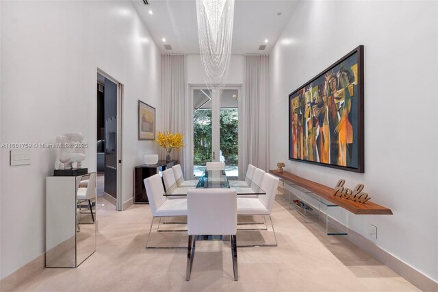 dining space featuring a high ceiling and a chandelier