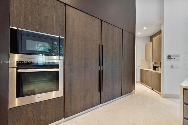 interior space featuring oven and dark brown cabinetry