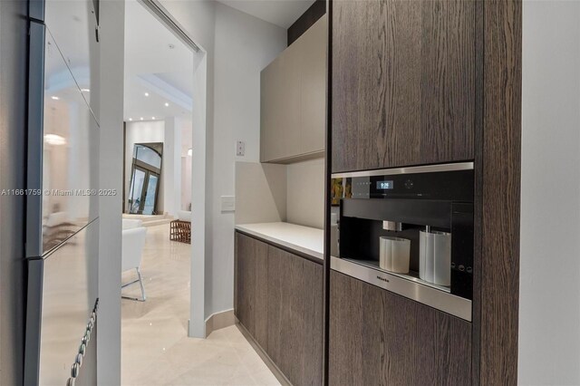 kitchen with dark brown cabinetry, a kitchen bar, a kitchen island, and sink