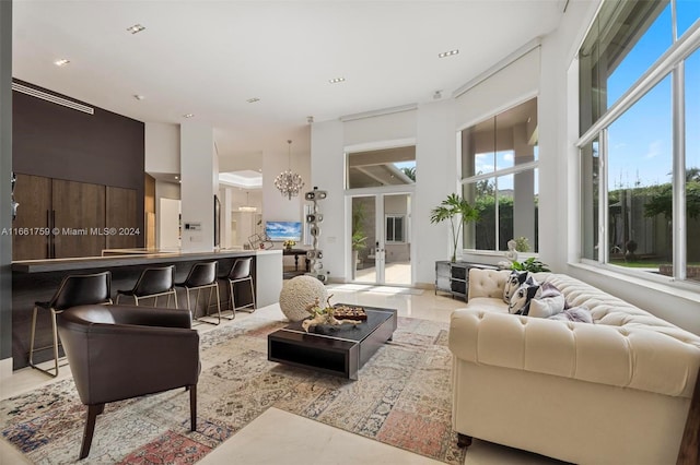 tiled living room featuring a high ceiling and french doors