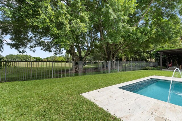 view of pool with a yard and pool water feature