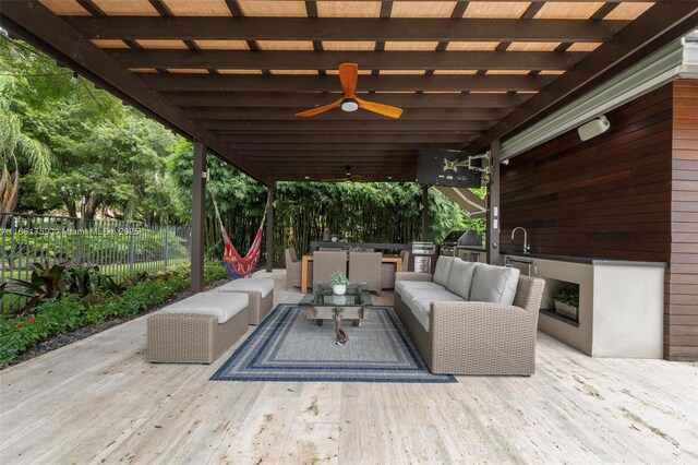 view of patio with ceiling fan, area for grilling, a swimming pool side deck, an outdoor living space, and an outdoor kitchen